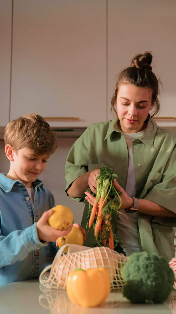 Une maman et son fils déballent ensemble leurs légumes frais Mon Marché en cuisine