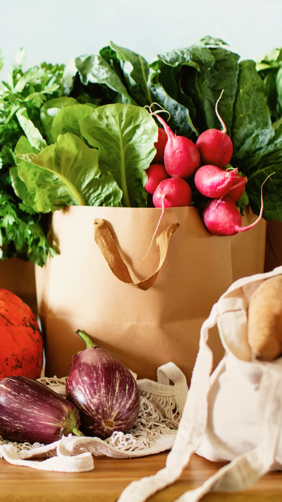 Un sac de courses Mon Marché rempli de légumes frais et d’aubergines